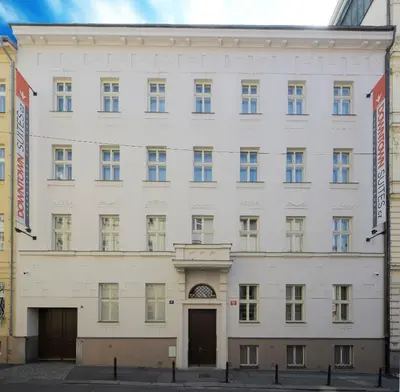 a large white building with two entrances at DownTown Suites Jugoslavska in Prague