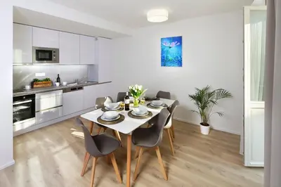 a kitchen and dining room with a table and chairs at DownTown Suites Jugoslavska in Prague