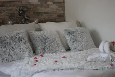 a bed with white pillows and a white blanket at Romantický wellness suite hotel Heinz in Dobříš