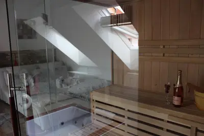 a room with a glass table and a bottle of wine at Romantický wellness suite hotel Heinz in Dobříš