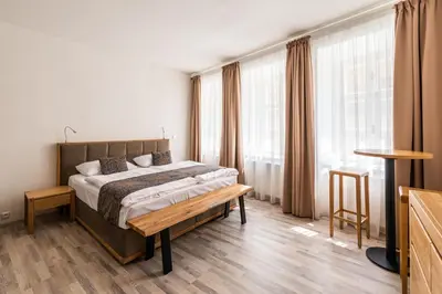 a bedroom with a bed and a table and windows at Hotel Karlova Prague - Mostecka 10 st Depandance in Prague