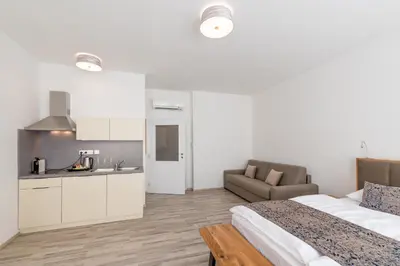 a bedroom with a bed and a kitchen and a couch at Hotel Karlova Prague - Mostecka 10 st Depandance in Prague