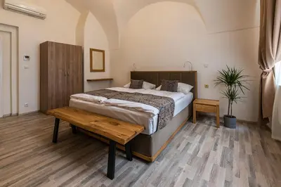 a bedroom with a large bed and a wooden table at Hotel Karlova Prague - Mostecka 10 st Depandance in Prague