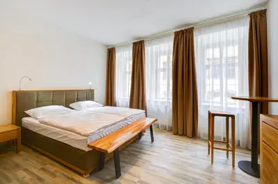 a bedroom with a bed with a bench in it at Hotel Karlova Prague - Mostecka 10 st Depandance in Prague