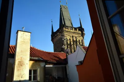 a tall church steeple in the sky behind some buildings at Hotel Karlova Prague - Mostecka 10 st Depandance in Prague