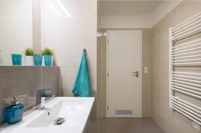 a bathroom with a white sink and a door at FREE PARKING IN GARAGE Karolina Plazza, new cosy studio with all you need in Prague