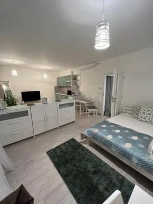 a bedroom with a bed and a kitchen and a living room at FREE PARKING IN GARAGE Karolina Plazza, new cosy studio with all you need in Prague