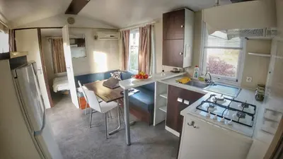 a small kitchen with a table and chairs in a caravan at Triocamp Praha in Prague