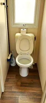 a small bathroom with a toilet with a window at Triocamp Praha in Prague