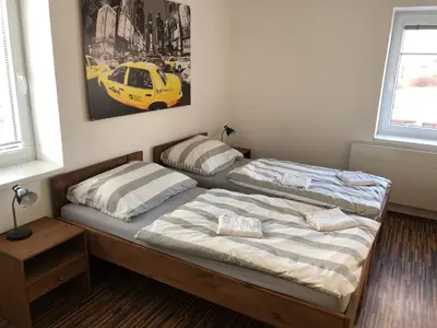 two beds in a bedroom with a yellow car on the wall at Motel Red Oil in Lovosice