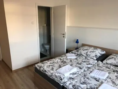 a bedroom with two beds and a bathroom with a toilet at Motel Red Oil in Lovosice