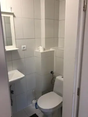 a white bathroom with a toilet and a sink at Motel Red Oil in Lovosice