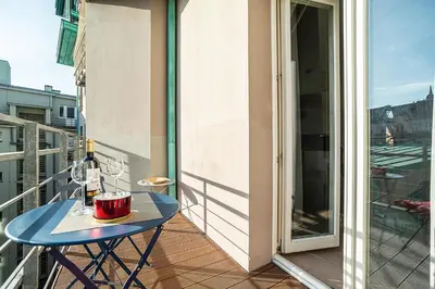 a table on a balcony with a bottle of wine at Modern Apt with portable AC and Cozy Terrace in Prague