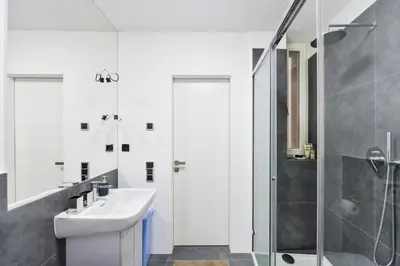 a white bathroom with a sink and a shower at Modern Apt with portable AC and Cozy Terrace in Prague