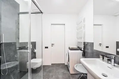 a bathroom with a sink and a toilet and a shower at Modern Apt with portable AC and Cozy Terrace in Prague