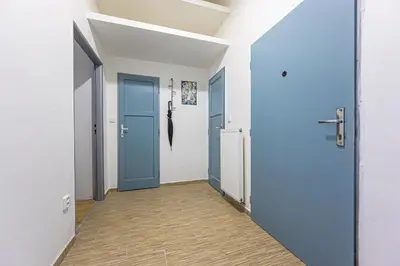 a hallway with two blue doors and a wooden floor at Apartments Grebovka in Prague