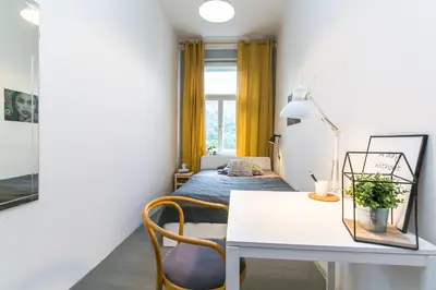 a bedroom with a bed and a table and chairs at Apartments Grebovka in Prague