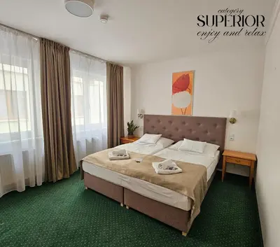 a bedroom with a large bed with two towels on it at Hotel Claris in Prague