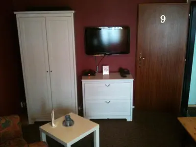 a living room with a tv and a white dresser at Pension Lucie in Prague