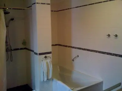 a bathroom with a tub and a shower with a towel at Pension Lucie in Prague