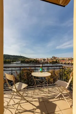 a patio with a table and chairs on a balcony at Bellevue Apartment in Prague