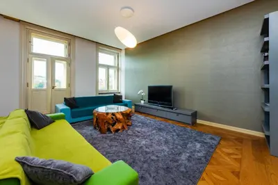 a living room with a yellow couch and a tv at Bellevue Apartment in Prague