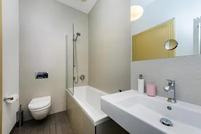 a bathroom with a sink and a toilet and a tub at Bellevue Apartment in Prague