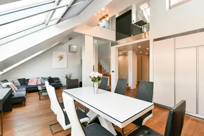 a dining room and living room with a white table and chairs at LUXURY CENTRAL DUPLEX WITH TERRACE in Prague