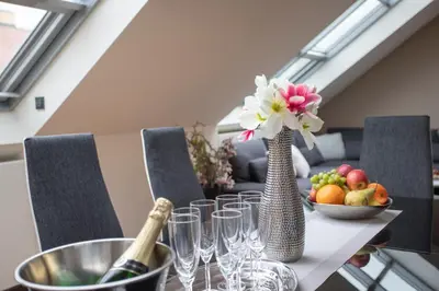 a table with a vase with flowers and a bowl of fruit at LUXURY CENTRAL DUPLEX WITH TERRACE in Prague