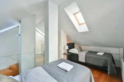 a bedroom with two beds and a skylight at LUXURY CENTRAL DUPLEX WITH TERRACE in Prague