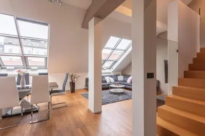 an open living room and dining room with stairs at LUXURY CENTRAL DUPLEX WITH TERRACE in Prague