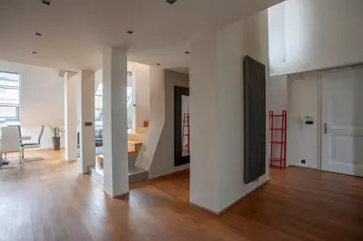 a living room with white walls and a wooden floor at LUXURY CENTRAL DUPLEX WITH TERRACE in Prague