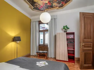 a bedroom with a bed and a lamp and a window at Art House Apartments by Adrez in Prague