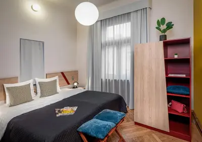a bedroom with a large bed and a blue chair at Art House Apartments by Adrez in Prague