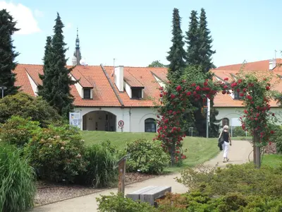 a woman walking down a path in front of a building at Hotel Floret in Pruhonice