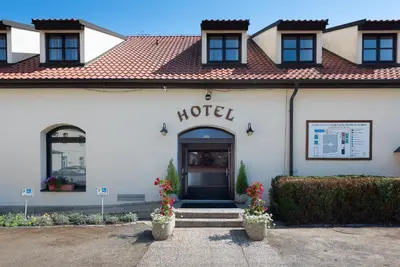 a hotel building with a door and flowers in front at Hotel Floret in Pruhonice