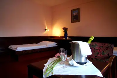 a hotel room with a table and a room with a bed at Hotel Floret in Pruhonice