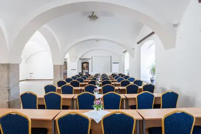 a row of tables and chairs in a room at Hotel Floret in Pruhonice