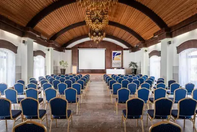 a room with rows of chairs and a screen at Hotel Floret in Pruhonice