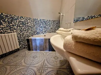 a living room with a leather couch and a bed at Family hotel Maxim in Beroun