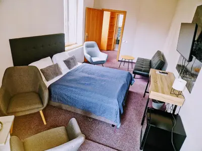 a living room with a chair and a couch at Family hotel Maxim in Beroun