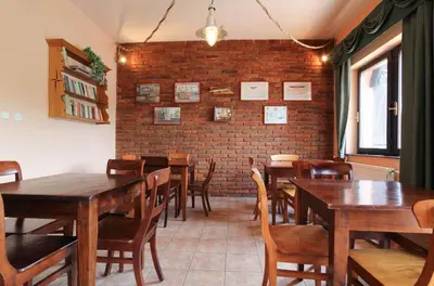 a restaurant with wooden tables and chairs and a brick wall at Hotel Laguna Slapy in Netvořice