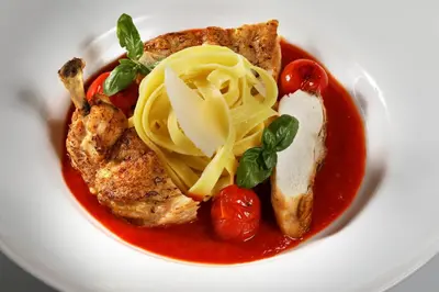 a plate of food with pasta and tomato sauce at Hotel Laguna Slapy in Netvořice