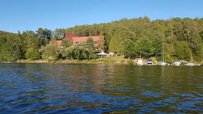 a house on the shore of a body of water at Hotel Laguna Slapy in Netvořice