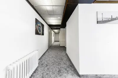 a hallway of an office with white walls and stairs at Hotel Oáza Praha in Prague
