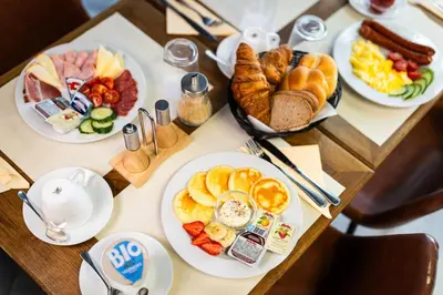 a table with plates of breakfast food on it at Hotel Oáza Praha in Prague