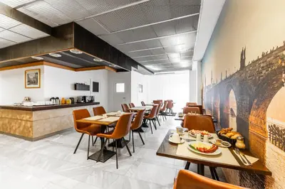 a restaurant with tables and chairs and a counter at Hotel Oáza Praha in Prague