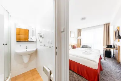 a hotel room with a bed and a sink at Hotel Oáza Praha in Prague