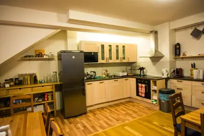 a kitchen with white cabinets and a black refrigerator at Onefam Míru in Prague