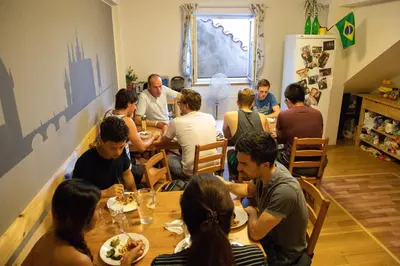 a group of people sitting at a table eating food at Onefam Míru in Prague